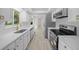 Modern kitchen with white cabinets, stainless steel appliances, granite countertops, and wood-look flooring at 7556 Sw 112Th Ln, Ocala, FL 34476