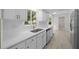 Modern kitchen with white cabinets, gold hardware, stainless steel appliances and quartz counters at 7556 Sw 112Th Ln, Ocala, FL 34476