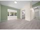 Spacious living room with light-colored wood floors and adjacent bathroom and kitchen area at 7556 Sw 112Th Ln, Ocala, FL 34476