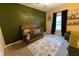 Adorable Bedroom with crib, dresser, and green accent wall at 7958 Juniper Rd, Ocala, FL 34480