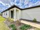 House's exterior, featuring a green front door, small porch and well-maintained landscaping at 9326 Sw 52Nd Loop, Ocala, FL 34481