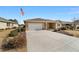 Tan one-story house with a two-car garage and American flag at 9840 Sw 90Th St, Ocala, FL 34481