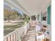 Long front porch with white railing and wicker furniture at 9981 Sw 101St Pl, Ocala, FL 34481