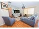 Living room featuring a sectional sofa, hardwood floors, and a large TV at 10602 Se 179Th Ln, Summerfield, FL 34491