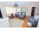 Spacious living room with a sectional sofa, hardwood floors, and large windows at 10602 Se 179Th Ln, Summerfield, FL 34491