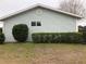 Side view of a house with light-blue siding and hedges at 10968 Sw 80Th Ct, Ocala, FL 34481