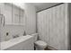Bright bathroom features a vanity, toilet, and shower with a patterned curtain at 11 Bahia Court Loop, Ocala, FL 34472