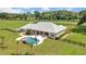 Aerial view of a home with pool, expansive lawn, and horse facilities at 12000 S Highway 475, Ocala, FL 34480