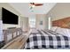 Main bedroom with large TV, hardwood floors, and ensuite bathroom access at 12000 S Highway 475, Ocala, FL 34480