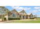 Stone and siding exterior of a single-story home showcasing a welcoming front porch and manicured landscaping at 12000 S Highway 475, Ocala, FL 34480