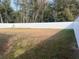 Large backyard with a white vinyl fence and open grassy area at 14351 Se 34Th Ct, Summerfield, FL 34491