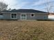 Rear view of a one-story house with sliding glass doors and a grassy yard at 14351 Se 34Th Ct, Summerfield, FL 34491