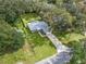 An aerial view shows the well-maintained property with a long driveway and mature trees providing shade at 205 Brevard Ave, Lady Lake, FL 32159