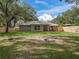 Private backyard with a fire pit, wooden fence, and patio area for outdoor relaxation and entertaining guests at 205 Brevard Ave, Lady Lake, FL 32159