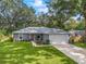 Newly constructed home with gray exterior, landscaping, and a two-car garage at 205 Brevard Ave, Lady Lake, FL 32159