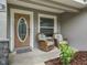 Charming front porch featuring a decorative front door, two wicker chairs and a small garden at 205 Brevard Ave, Lady Lake, FL 32159