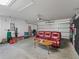 Spacious garage features a red couch, wood table and overhead door at 205 Brevard Ave, Lady Lake, FL 32159