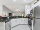 Well-lit kitchen featuring granite counters, stainless steel appliances, and white cabinetry at 205 Brevard Ave, Lady Lake, FL 32159
