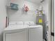 Bright laundry room features washer, dryer, shelving and hot water heater at 205 Brevard Ave, Lady Lake, FL 32159