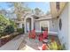 Inviting front porch with stone pavers, red Adirondack chairs, and attractive landscaping at 2412 Se 23Rd Pl, Ocala, FL 34471