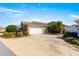 Single story home with a two-car garage and mature landscaping at 2997 Teasdale Ter, The Villages, FL 32163
