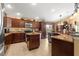 Island kitchen with dark wood cabinets, granite countertops, and stainless steel appliances at 2997 Teasdale Ter, The Villages, FL 32163