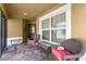 Covered porch with wicker chairs and a glass-top table at 2997 Teasdale Ter, The Villages, FL 32163