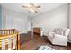 Bedroom featuring a crib, armchair, and ceiling fan at 302 Brookstone Ln, Fruitland Park, FL 34731