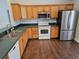 Kitchen with wood cabinetry, stainless steel appliances, and a double stainless steel sink at 3752 Se 130Th St, Belleview, FL 34420