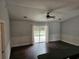 Open-concept living room featuring sliding glass doors, dark laminate flooring, and updated fixtures at 3752 Se 130Th St, Belleview, FL 34420