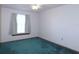 Simple bedroom with teal carpet and window at 4960 Se 17Th St, Ocala, FL 34471