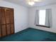 Bright bedroom with teal carpet, window, and built-in closet at 4960 Se 17Th St, Ocala, FL 34471