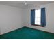 Well-lit bedroom featuring teal carpet and a window at 4960 Se 17Th St, Ocala, FL 34471