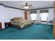 Main bedroom with teal carpet, ceiling fan and large mirrored closet at 4960 Se 17Th St, Ocala, FL 34471