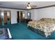 Main bedroom with teal carpet, mirrored closet and floral bedding at 4960 Se 17Th St, Ocala, FL 34471