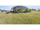 Spacious backyard with a screened enclosure and lush landscaping at 5141 Greens Dr, Lady Lake, FL 32159