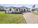 White two-story house with manicured lawn and paver driveway at 5141 Greens Dr, Lady Lake, FL 32159