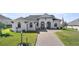 Two-story house with white walls, gray roof, and a brick driveway at 5141 Greens Dr, Lady Lake, FL 32159