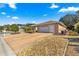 Front view of a single-story house with a driveway and landscaping at 8125 Sw 81St Loop, Ocala, FL 34476