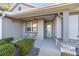 Covered front porch with light-green door and seating area at 822 Nw 45Th Pl, Ocala, FL 34475