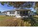 Rear view of house showcasing a screened porch and yard at 822 Nw 45Th Pl, Ocala, FL 34475