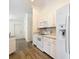 White kitchen with wood-look floors and stainless steel appliances at 8574 Sw 60Th Ct, Ocala, FL 34476