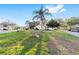 Well-maintained front yard featuring green grass, mature palm tree, and unique rock outcroppings at 8648 Sw 95Th Ln # A, Ocala, FL 34481