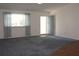 Spacious living room with gray carpet, wood flooring, and a view of the front door at 8667 Sw 108Th Pl, Ocala, FL 34481