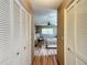 Hallway view leading into a cozy bedroom with wood floors and a ceiling fan enhancing its charm at 9331 Sw 84Th Ter # F, Ocala, FL 34481