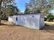 A large storage shed with a garage door and a side door at 10043 Sw 202Nd Cir, Dunnellon, FL 34431