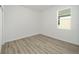 Simple bedroom with wood-look flooring and a window overlooking the yard at 10322 Sw 99Th Ln, Ocala, FL 34481