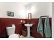 Simple bathroom with pedestal sink, toilet, and dark wood wainscoting at 10425 Se 159Th Lane, Summerfield, FL 34491