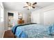 Bedroom with hardwood floors, ceiling fan, and en-suite bath at 10425 Se 159Th Lane, Summerfield, FL 34491