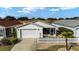 Aerial view of a well-maintained home with an attached garage and a white picket fence at 1112 Carvello Dr, The Villages, FL 32162